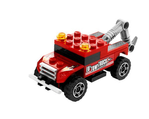 Red LEGO tow truck with flame decals, 'ED'S TOW TRUCK SERVICE' on side, and a gray tow hook.