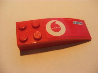 Red LEGO curved slope brick with four studs, featuring a white Vodafone logo and a smaller Fiat logo sticker.