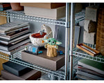 LEGO Star Wars 75304 Grogu (The Child) and Hover Pram display set on a metal shelf with books.