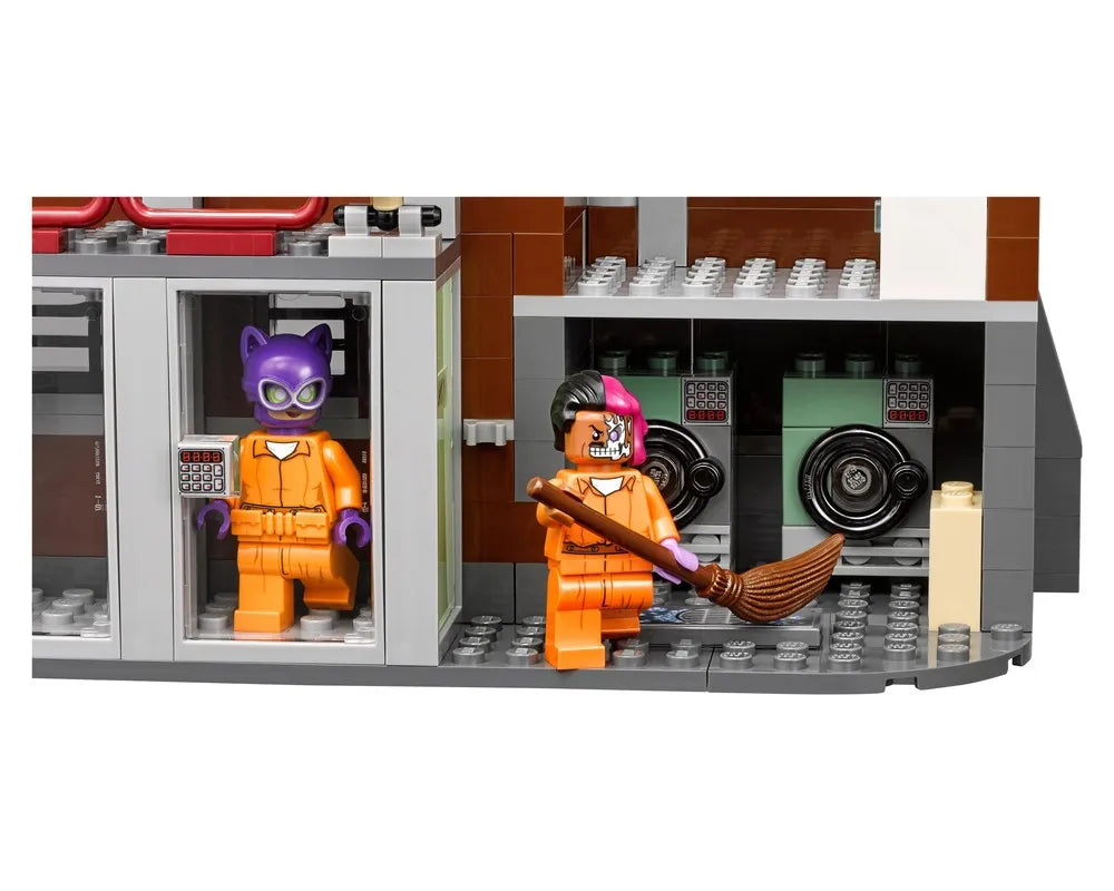 LEGO Arkham Asylum set with Catwoman and Two-Face minifigures in orange prison jumpsuits, with cells and safe doors.