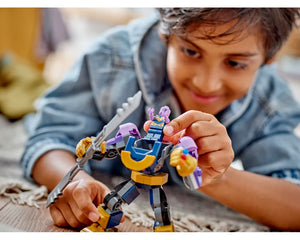 Boy playing with LEGO Super Heroes 76242 Thanos Mech Armor, placing Thanos minifigure into the large purple mech.
