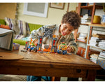 Smiling boy plays with LEGO Super Mario 72039 Bowser's Castle set, featuring Bowser, Yoshi, and a castle gate.