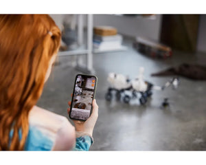 Person holding phone displaying AR experience of LEGO Mars Rover Perseverance with the physical model in background.